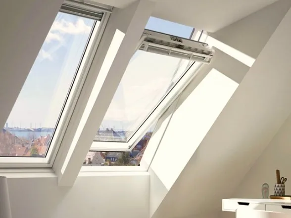 Open VELUX roof window letting light and air into a loft